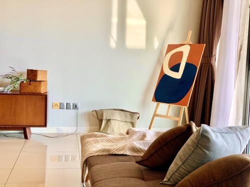 a living room with a couch and a painting on the wall at Deco Home @ Imago The Loft in Kota Kinabalu
