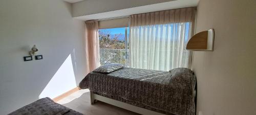 een slaapkamer met een bed en een groot raam bij La mejor vista a las Montañas y la Ciudad in Mendoza