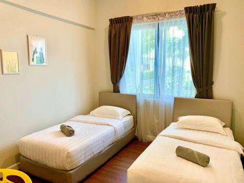 two beds in a room with a window at Deco Home @ Imago The Loft in Kota Kinabalu