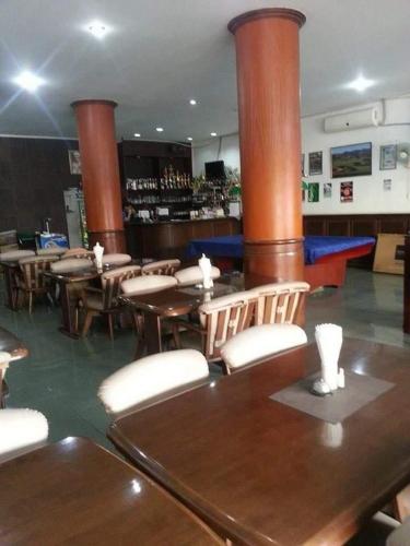 a restaurant with wooden tables and chairs and a bar at the links hotel in Pattaya