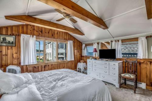 een slaapkamer met een bed, een tv en ramen bij Bell Buoy in Rockport