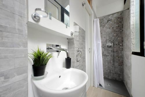a white bathroom with a sink and a shower at Katia Charme in Rome