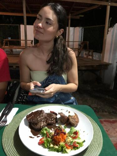 una mujer sentada en una mesa con un plato de comida en Tayrona Shalom Bait, en Santa Marta