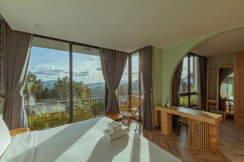 a bedroom with a bed and a large window at La Villa Da Lat in Khu Chi Lăng