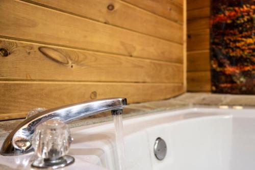a sink with a faucet in a bathroom at Romantic log cabin with hot tub in Pigeon Forge