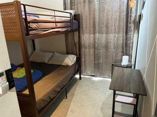 Cette petite chambre comprend des lits superposés et une table. dans l'établissement Neu suites 007- 2 bedrooms klcc, à Kuala Lumpur