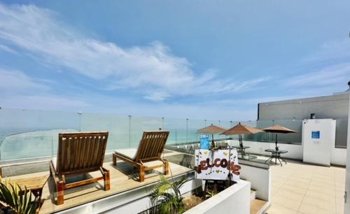 2 sillas sentadas en un balcón con vistas al océano en Casa Sol Apartamento vista al mar cerca del aeropuerto y Miraflores en Lima