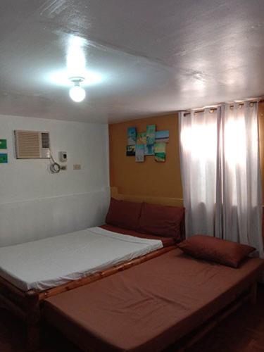 a small bedroom with two beds and a window at Casa Astillero - Calatagan Batangas Private Resort in Calatagan
