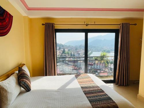 a bedroom with a bed and a large window at Sapa Paramount Hotel in Sa Pa