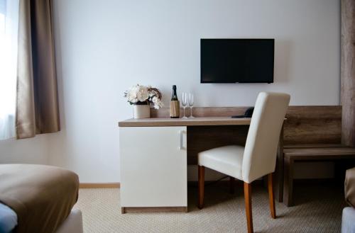 a room with a desk with a chair and a television at Hotel Soldo in Međugorje