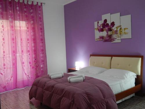 a bedroom with a bed with purple walls and curtains at Casa Vacanze Karol in Trappeto