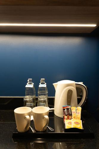a tray with two bottles of water and two cups at Centara Life Hotel Bangkok Phra Nakhon in Bangkok