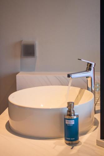 a bottle of soap next to a bathroom sink at Centara Life Hotel Bangkok Phra Nakhon in Bangkok