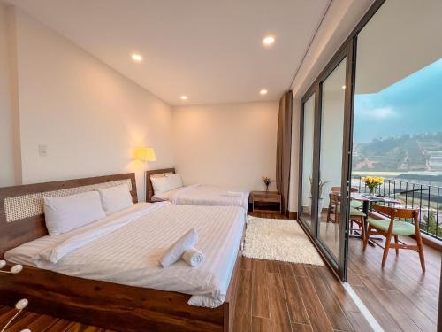 a bedroom with two beds and a balcony at The Green House Villa in Da Lat