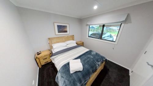 Habitación pequeña con cama y ventana en 5 Bedroom, Solar on Snowmass Ohakune, Yellow Door en Ohakune