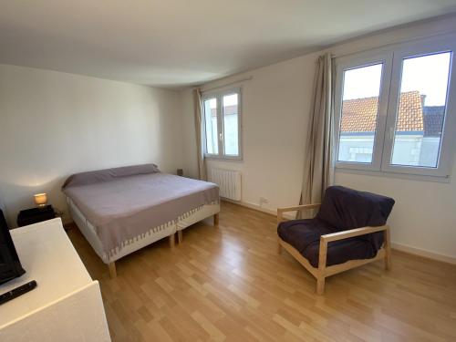 une chambre avec un lit, une chaise et des fenêtres dans l'établissement Maison à Fouras, 3 chambres, cour ombragée, proche centre et plages - FR-1-709-67, à Fouras