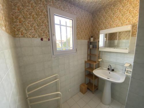 une salle de bain avec un lavabo et un miroir dans l'établissement Maison à Fouras, 3 chambres, cour ombragée, proche centre et plages - FR-1-709-67, à Fouras
