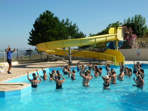 un gruppo di persone in una piscina con scivolo di Mobil-Home Fouras, 4 pièces, 6 personnes - FR-1-709-68 a Fouras