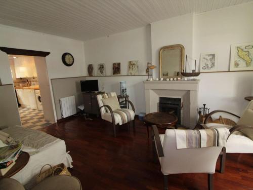 - un salon avec une cheminée, une table et des chaises dans l'établissement Maison de charme à Saint-Georges-d'Oléron, 8 couchages, proche commerces, cour et terrasse ensoleillée - FR-1-246A-237, à Saint-Georges-dʼOléron