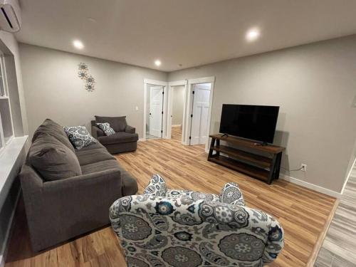 a living room with a couch and a tv at New ranch on RIVER with spectacular views in Brewer