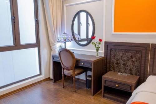 1 dormitorio con escritorio y espejo en Sophia Hotel en Hai Phong