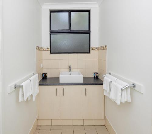 łazienka z umywalką, oknem i ręcznikami w obiekcie BIG4 Emu Beach Holiday Park w mieście Albany