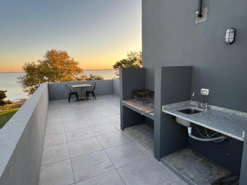 a patio with a table and two sinks on a balcony at Atardeceres Chascomús in Chascomús