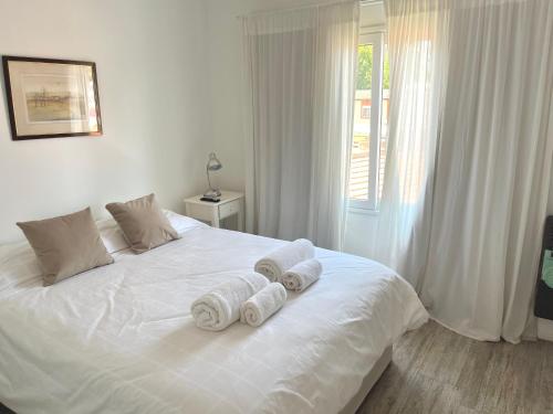 a bedroom with a white bed with towels on it at Atardeceres Chascomús in Chascomús
