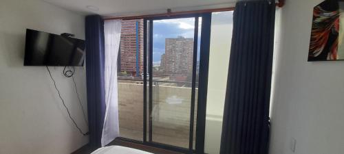 a room with a window with a view of a city at Wohnung Queens Deluxe in Bogotá
