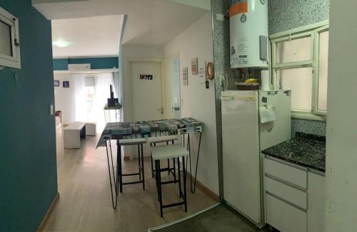 cocina con nevera y mesa con taburetes en Departamento céntrico excelente ubicación en Mar del Plata