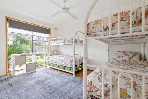 two bunk beds in a room with a window at Plover Haven in Cowes