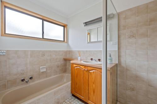 a bathroom with a tub and a sink and a shower at Plover Haven in Cowes