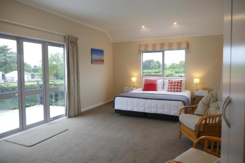 a bedroom with a bed and a large window at Lodge On St Georges in Havelock North