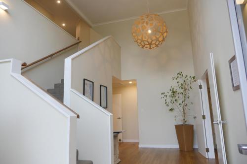 a hallway with white walls and a chandelier at Lodge On St Georges in Havelock North
