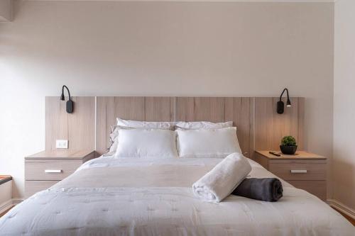 a bedroom with a large white bed with wooden walls at Primera línea, Viña del Mar-ByHospédate in Viña del Mar