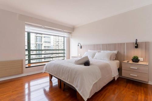- une chambre blanche avec un grand lit et une fenêtre dans l'établissement primera linea viña del mar, à Viña del Mar