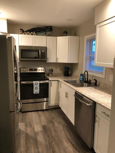 a kitchen with stainless steel appliances and white cabinets at Spacious Home near Airport in Bangor