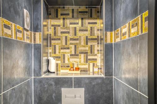 a bathroom with blue tiles and a shelf with books at L'Eden Love - Jacuzzi / Sauna in Grenoble
