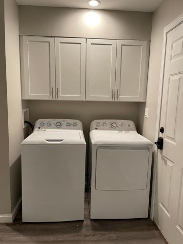 a kitchen with white cabinets and two washers at Spacious Home near Airport in Bangor