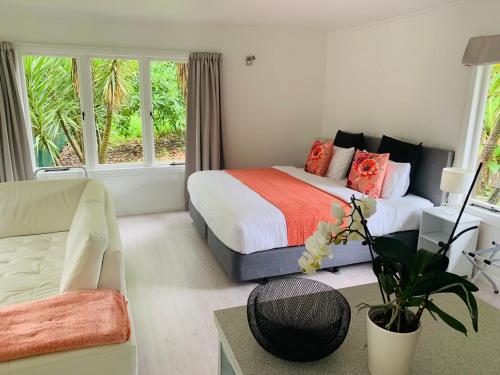 ギズボーンにあるLa Frontiere Boutique Accommodationのベッドとソファのある寝室