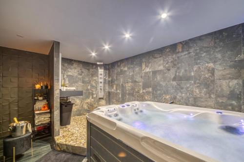 a bathroom with a large tub in a room at L'Eden Love - Jacuzzi / Sauna in Grenoble