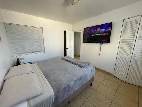 a bedroom with a bed and a flat screen tv at Beachfront, sun, sand & fun - Cozy 1 Bdr Apt in Tijuana