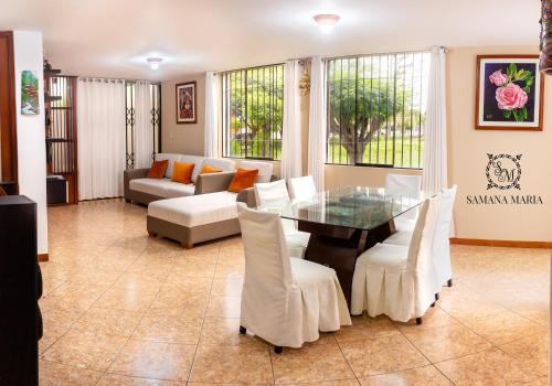 SSAMANA MARÍA APARTMENT 102 في أريكيبا: غرفة معيشة مع طاولة زجاجية وكراسي بيضاء
