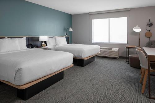 pokój hotelowy z 2 łóżkami i stołem w obiekcie TownePlace Suites by Marriott Buckeye Verrado w mieście Buckeye