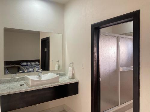 a bathroom with a sink and a mirror at HOTEL & RV PARK ROSA EVELYN in San Quintín