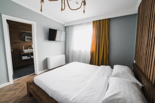 ein Schlafzimmer mit einem weißen Bett und einem Fenster in der Unterkunft Voronet Noir Chalet in Woronetz