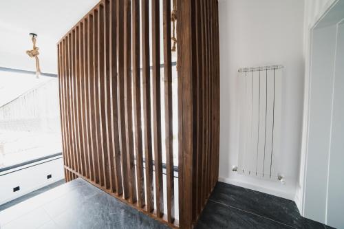 una escalera de madera en una habitación con una cruz en la pared en Voronet Noir Chalet en Voronet