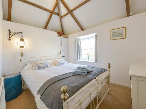 a bedroom with a bed in a room with a window at 2 Trerise Cottage in Helford