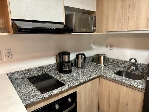a kitchen with a sink and a counter top at 2 Dormitorios Edificio Zetta Village Airport in Colonia Mariano Roque Alonso
