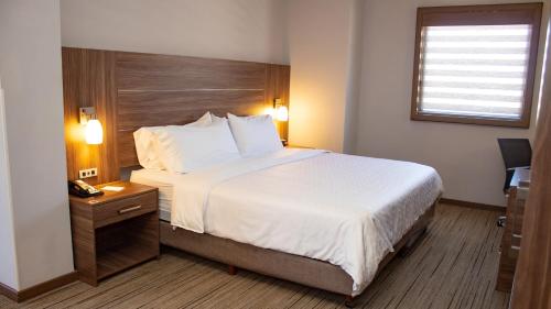 a hotel room with a large bed and a window at Holiday Inn Express Guaymas by IHG in Guaymas